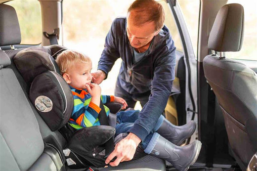 Father fastening seatbelt for his baby 